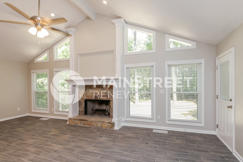 a living room with a fireplace and a ceiling fan