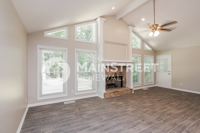a living room with a fireplace and a ceiling fan