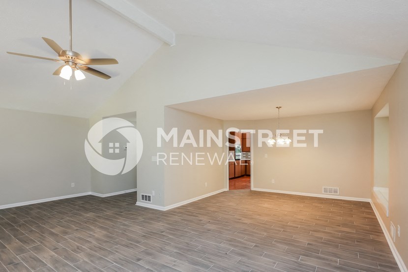 a living room with wood floors and a ceiling fan