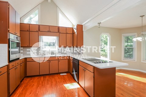 a renovated kitchen with wooden floors and wooden cabinets