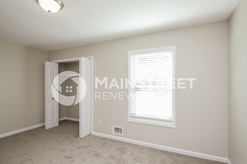 a bedroom with a closet and a window