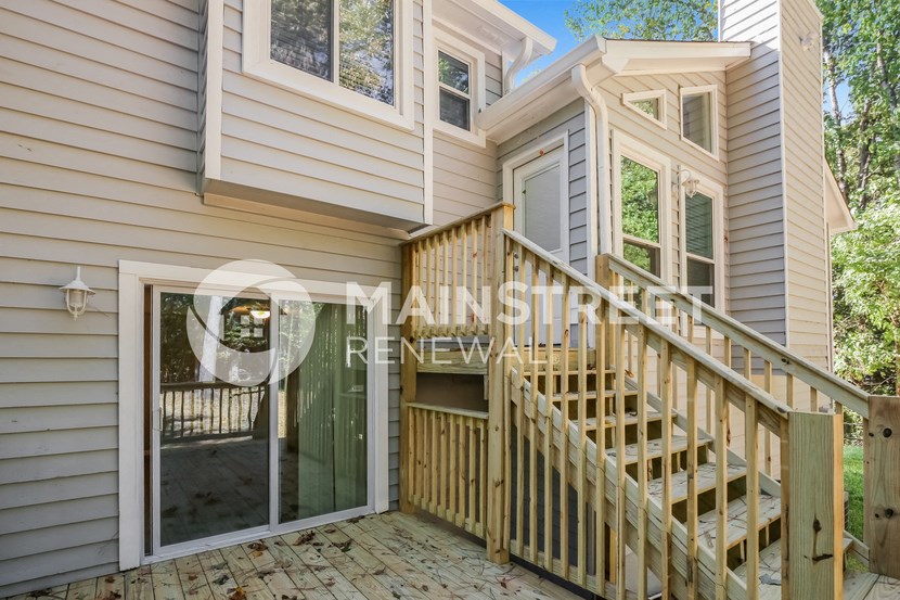 a side view of a house with a staircase and a glass door