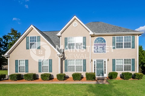 a house with green shutters and a lawn