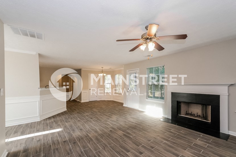 a living room with a fireplace and a ceiling fan