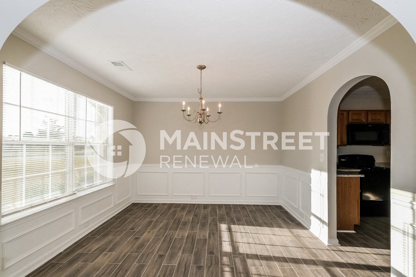 a dining room with white walls and a chandelier
