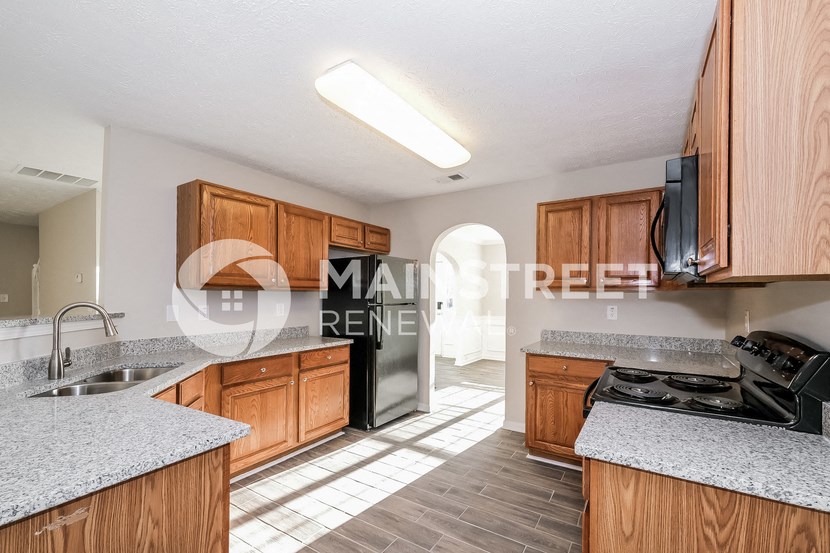 a kitchen with wooden cabinets and a stainless steel refrigerator