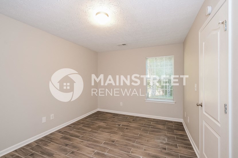 a bedroom with a white door and a window