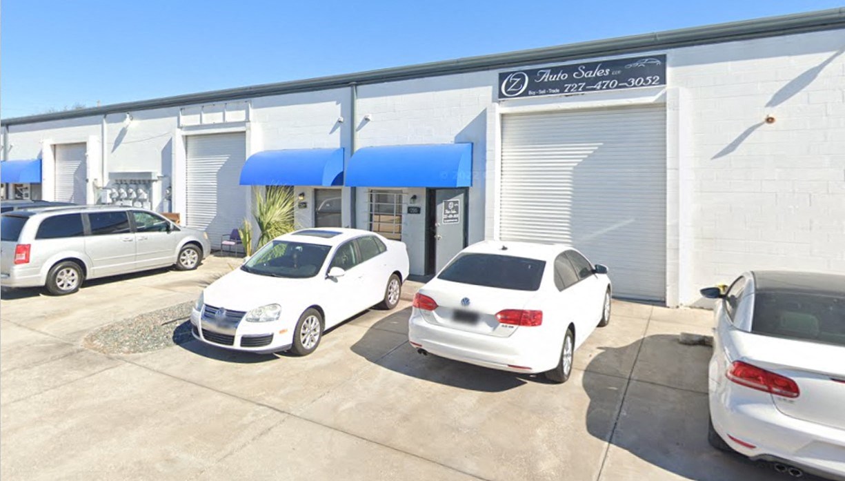 a car dealership with cars parked in front of it