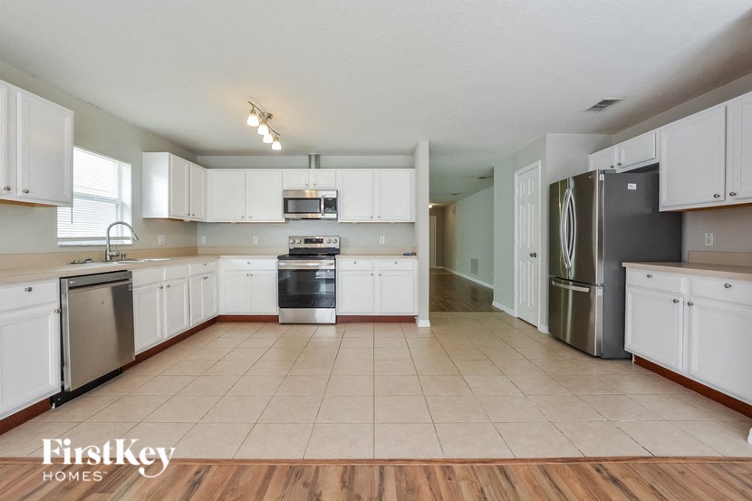 A kitchen with white cabinets and appliances.