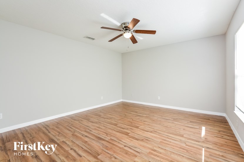 A room with a wooden floor and a ceiling fan.