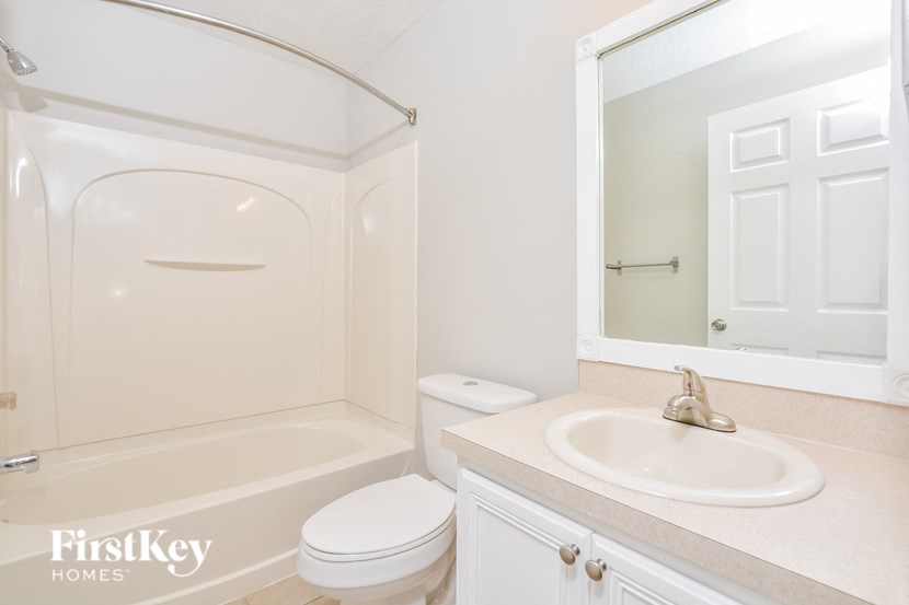 A white bathroom with a tub, toilet and sink.
