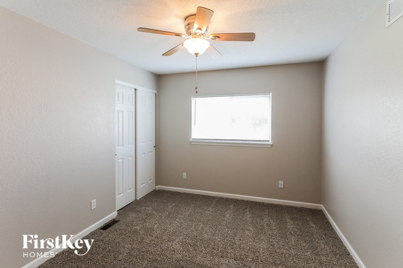 a bedroom with a ceiling fan and a window