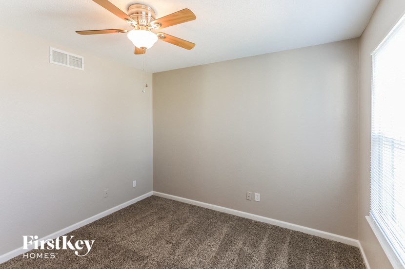 a room with carpet and a ceiling fan