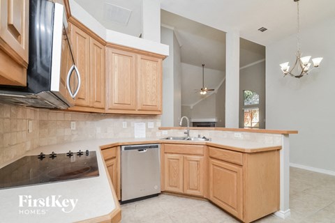 A kitchen with wooden cabinets and a stainless steel refrigerator.