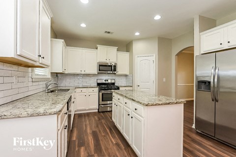 a kitchen with white cabinets and stainless steel appliances