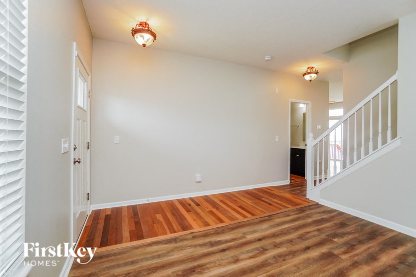 an empty living room with wood flooring and a staircase