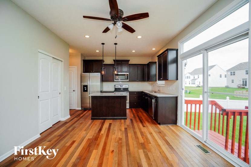 a kitchen with a large window and a wooden floor