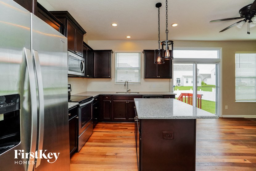 a kitchen with stainless steel appliances and wooden floors