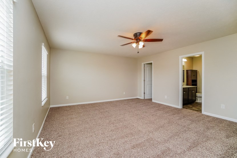 a living room with carpet and a ceiling fan