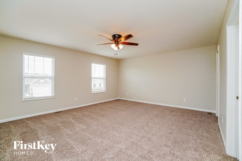 an empty living room with a ceiling fan