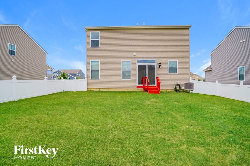 a backyard with a house and a green lawn