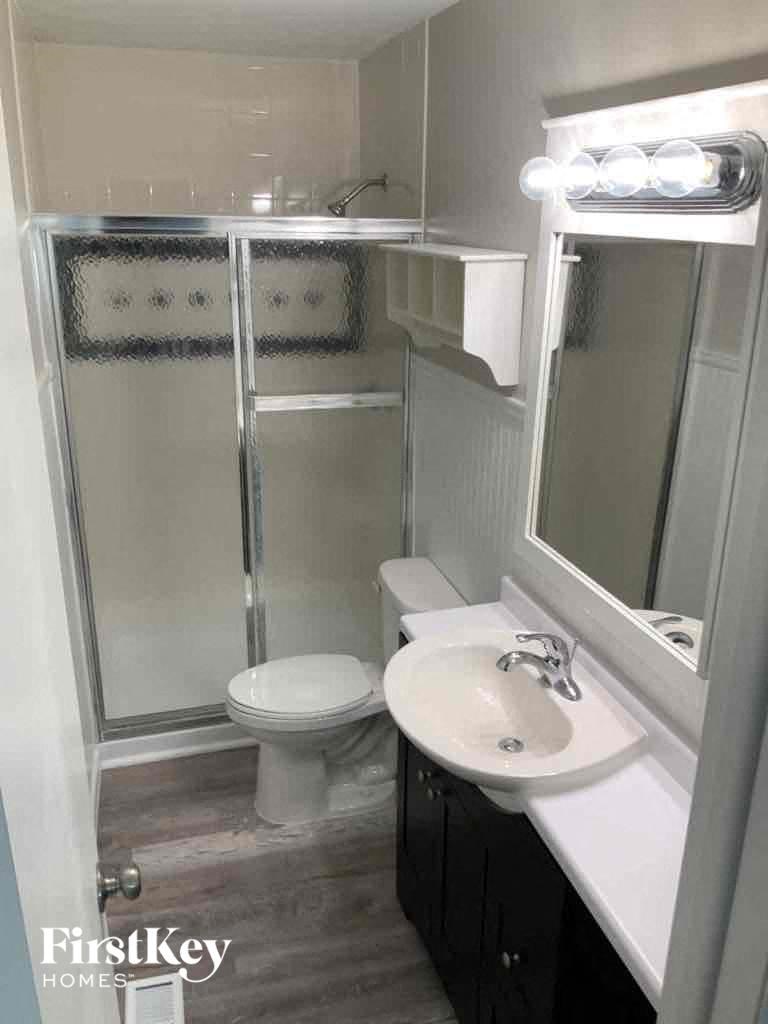 a small bathroom with a shower toilet and sink