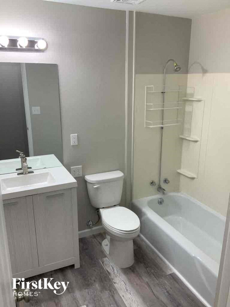 a bathroom with a toilet and a sink and a bath tub