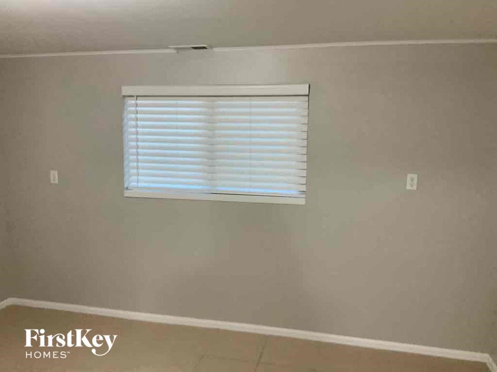 a living room with a window and a wall with white blinds