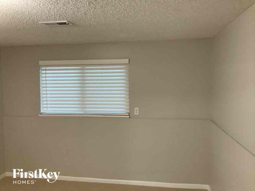 a small room with a window and a white wall