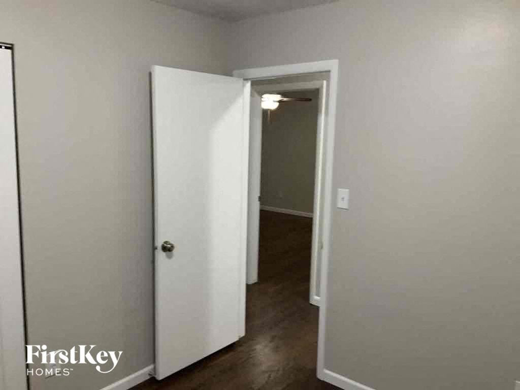 an empty room with a door open to a hallway with a closet