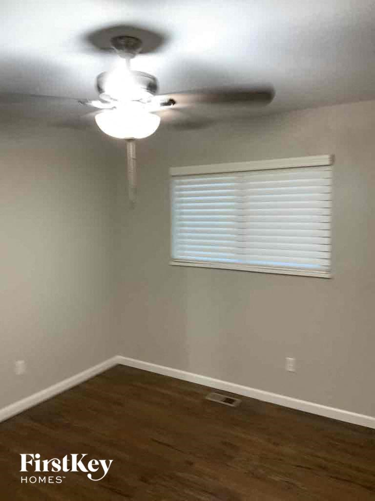 an empty room with a ceiling fan and a window