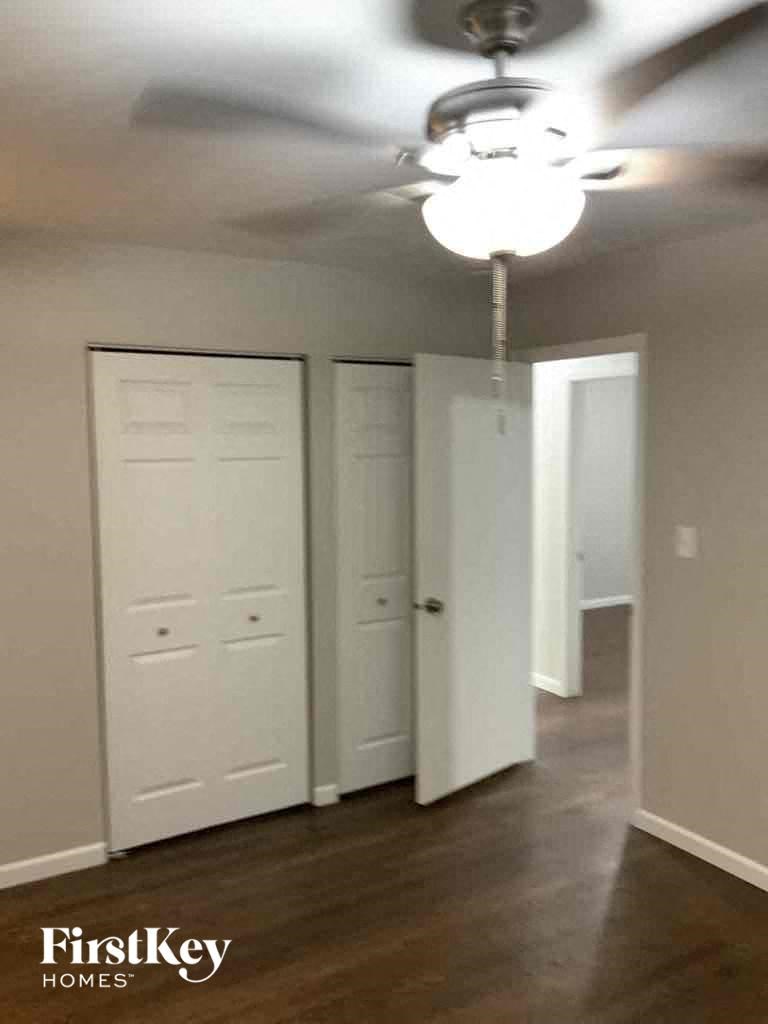 an empty room with a ceiling fan and a closet