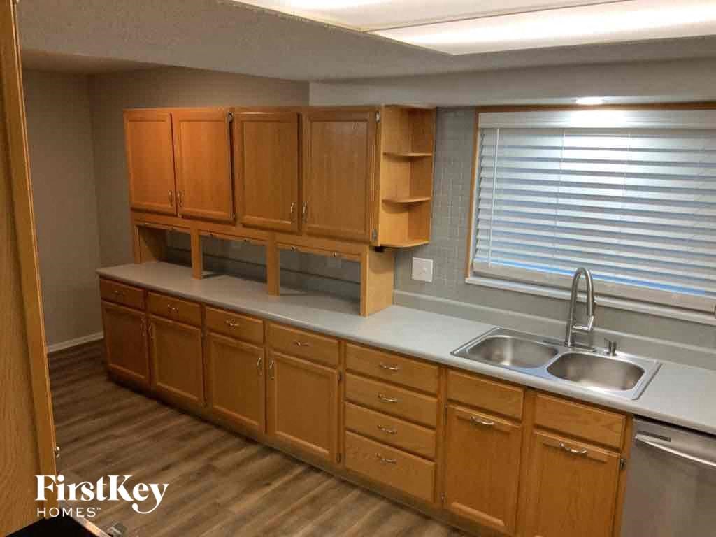 an empty kitchen with wooden cabinets and a sink