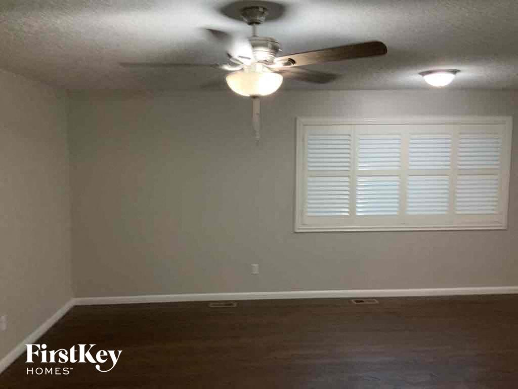 a empty room with a ceiling fan and a window