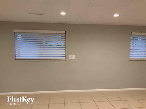 a living room with two windows and a tiled floor
