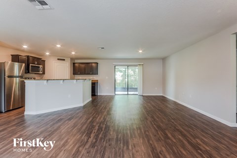 A spacious kitchen with wooden floors and a white countertop.