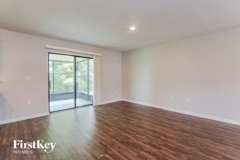 A room with wooden floors and a sliding glass door.