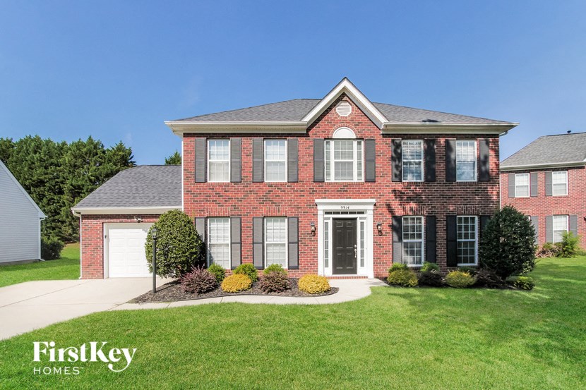 A brick house with a black door and windows.