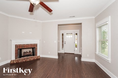 a living room with a fireplace and a ceiling fan