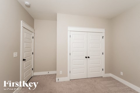 a bedroom with two closets and two doors