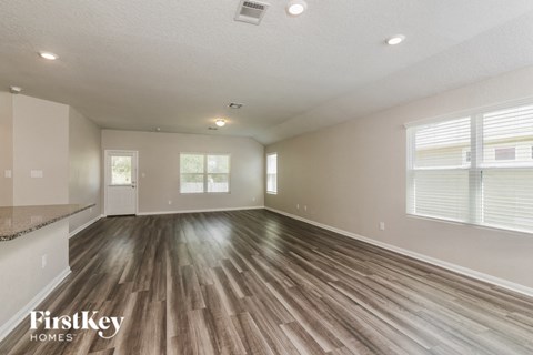 A spacious room with wooden flooring and a FirstKey Homes logo.