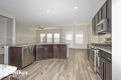A kitchen with a stove top oven and a refrigerator.