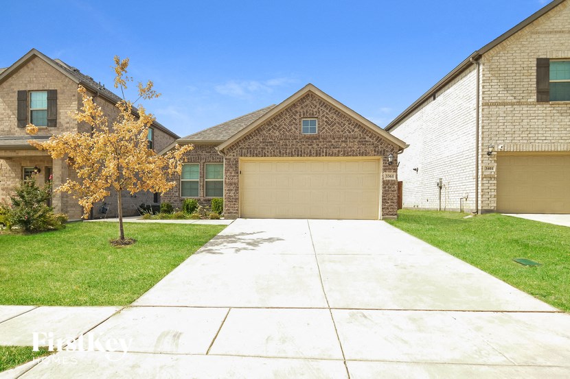 an empty driveway in front of a brick house