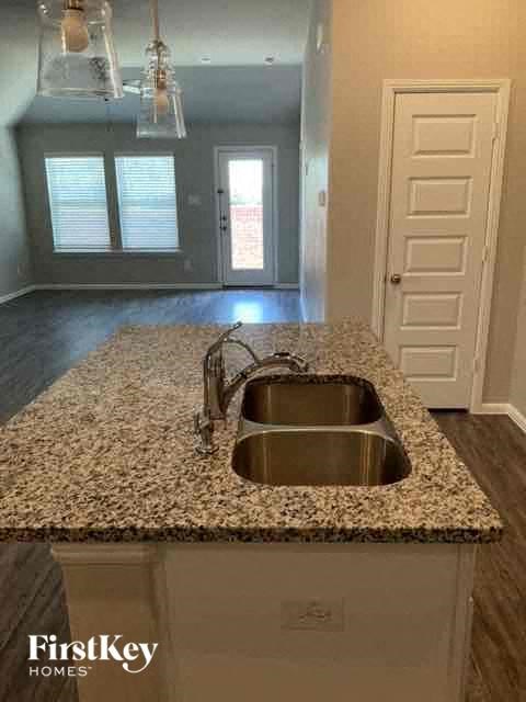 an empty kitchen with a sink and granite counter top