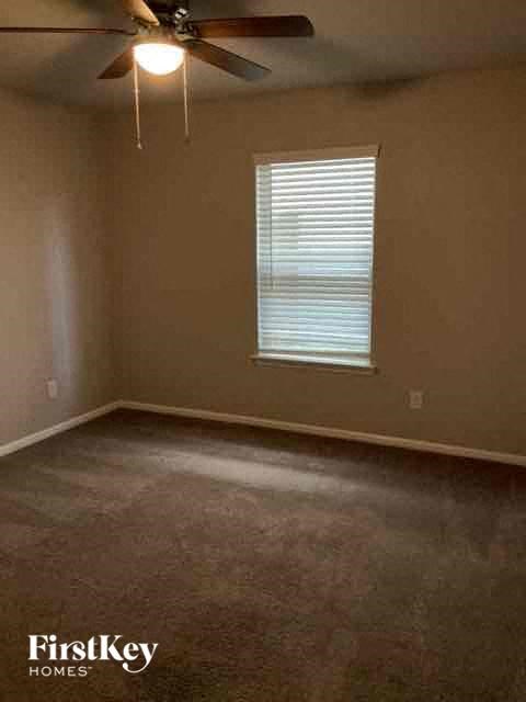 an empty room with a ceiling fan and a window