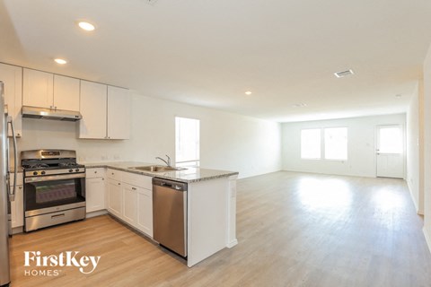 A kitchen with white cabinets and a stainless steel dishwasher and oven.