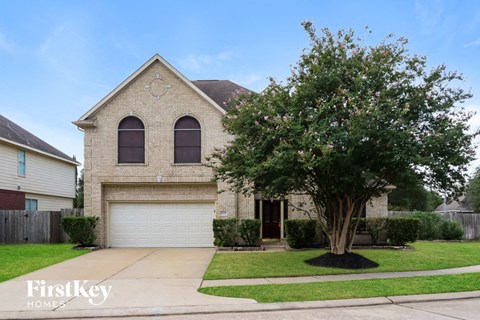 a brick house with a tree in the yard