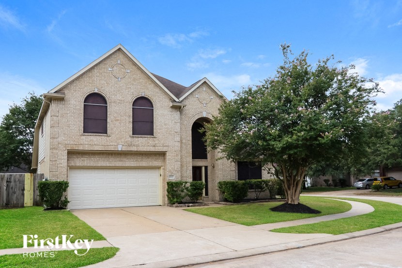 a brick house with a white garage door and a tree