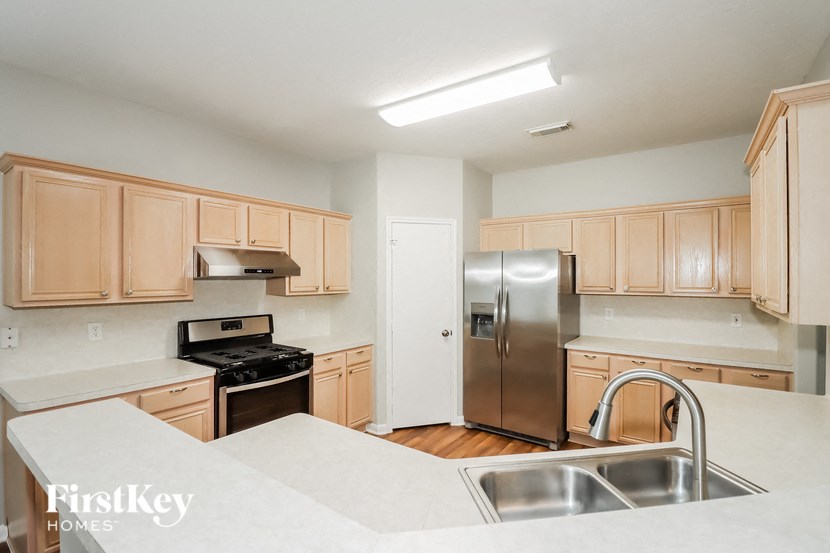 a kitchen with wooden cabinets and a stainless steel refrigerator