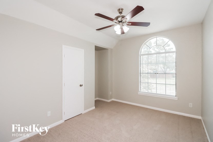 a bedroom with a ceiling fan and a window